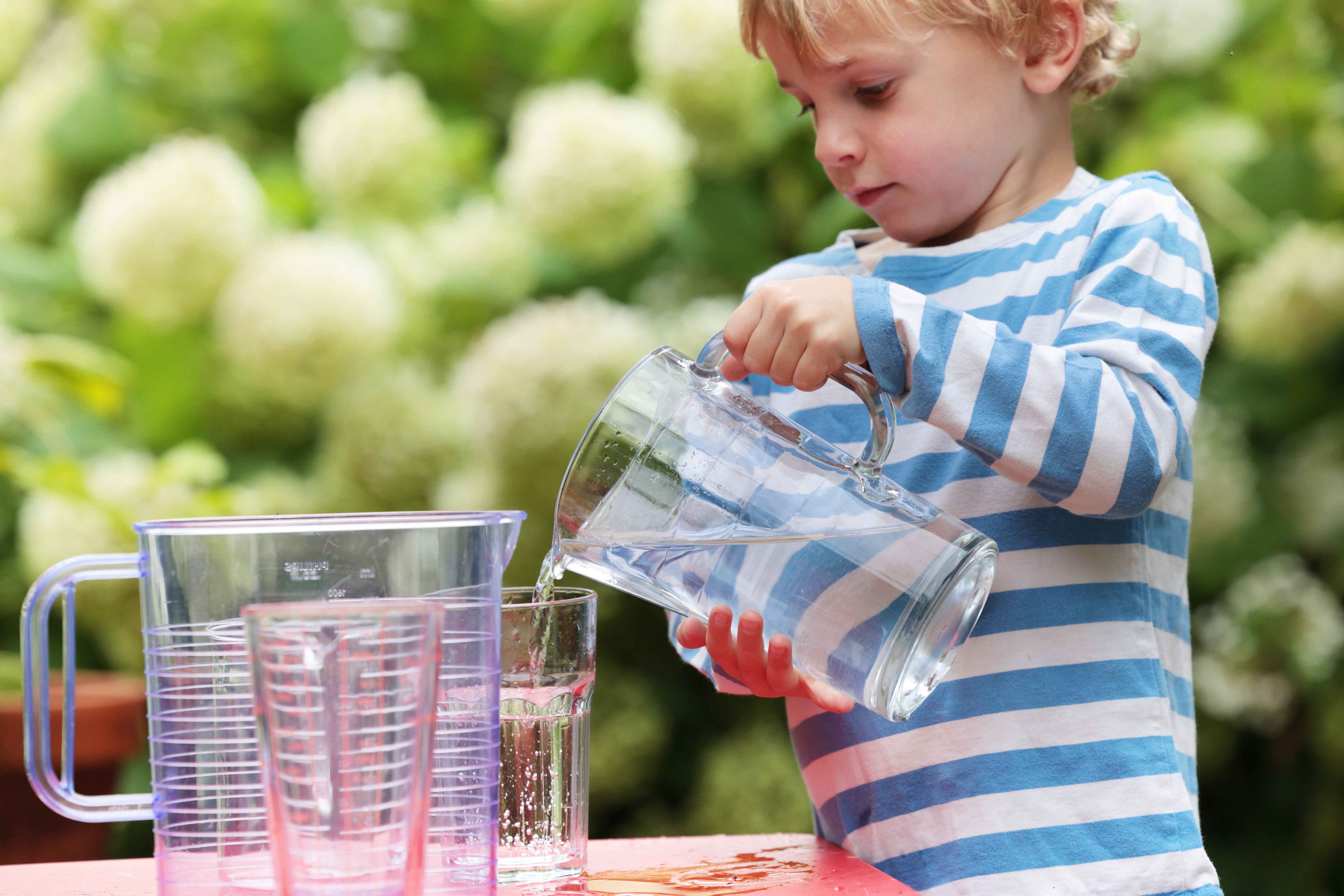 Child pour water from a jug