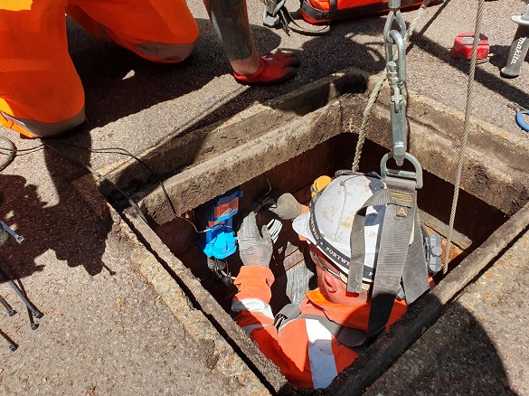 Thames engineer installing a monitor under a road