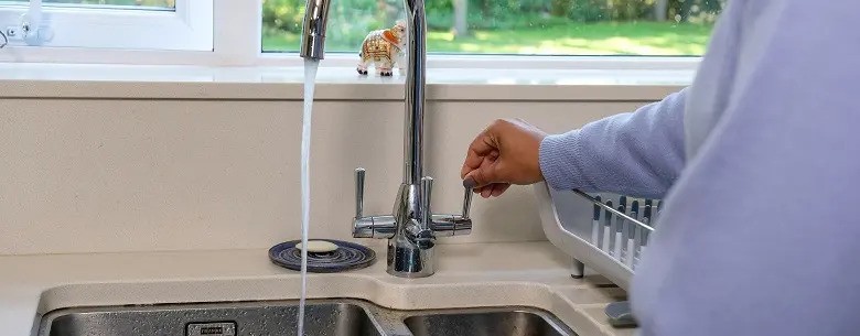 Man turning on a tap