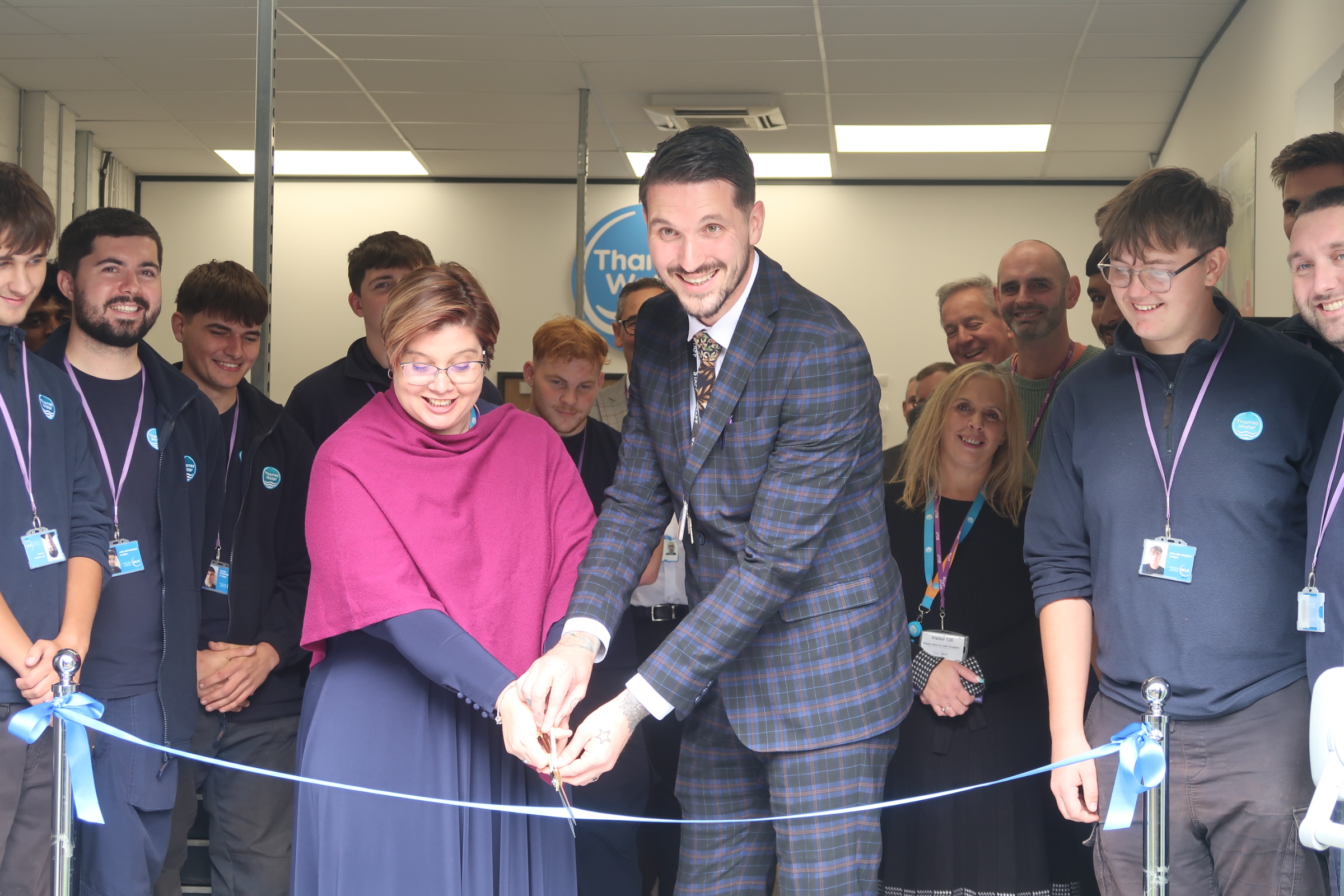 A woman and a man cut a ribbon using a pair of scissors