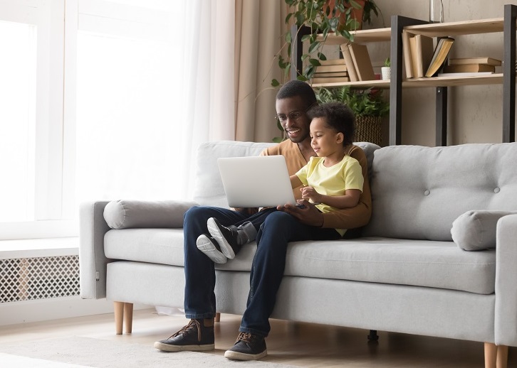 family using laptop on sofa