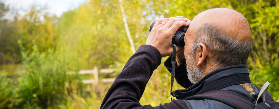 Man watching birds through binoculars