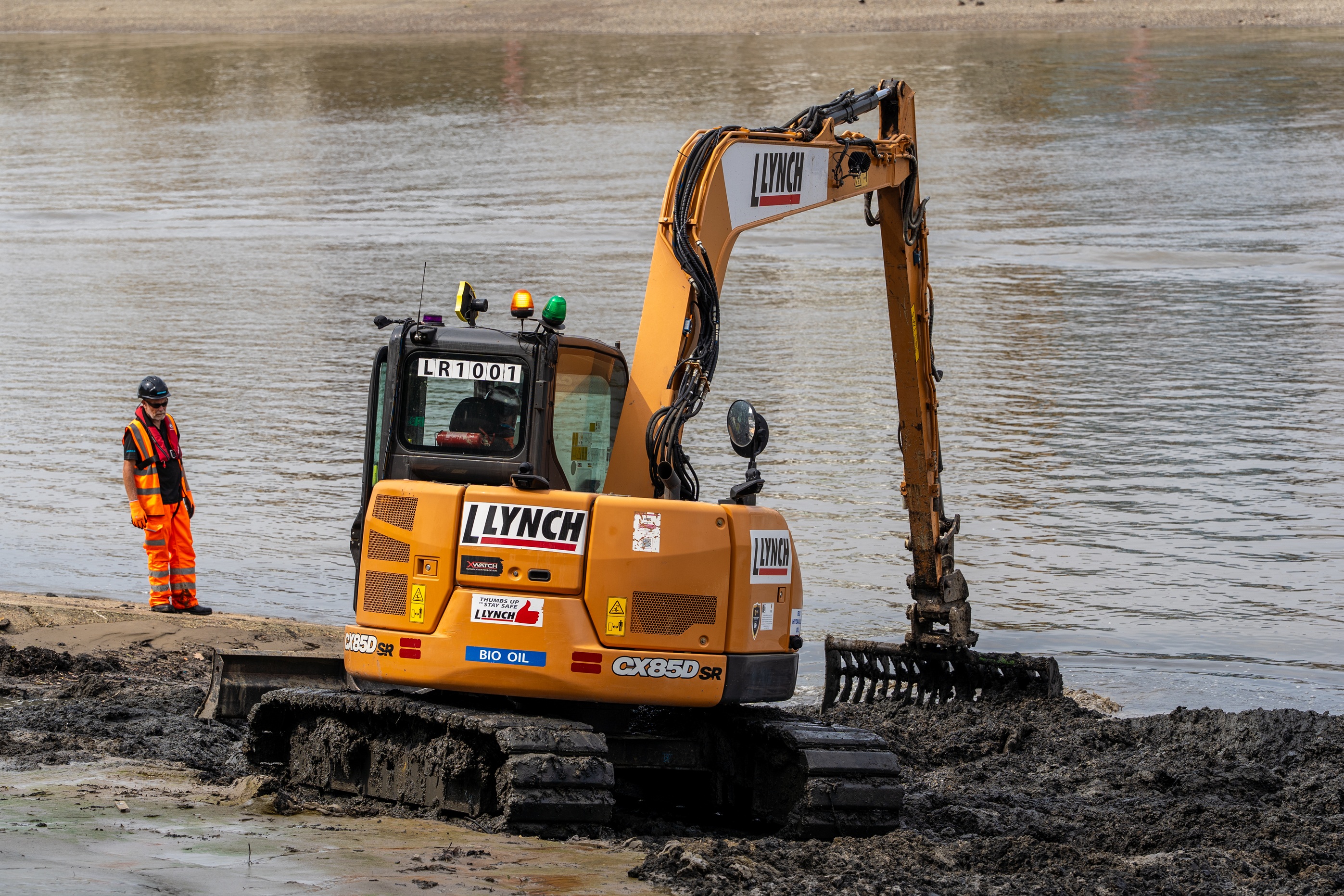 A digger works to remove Wet Wipe Island in London near Hammersmith Bridge