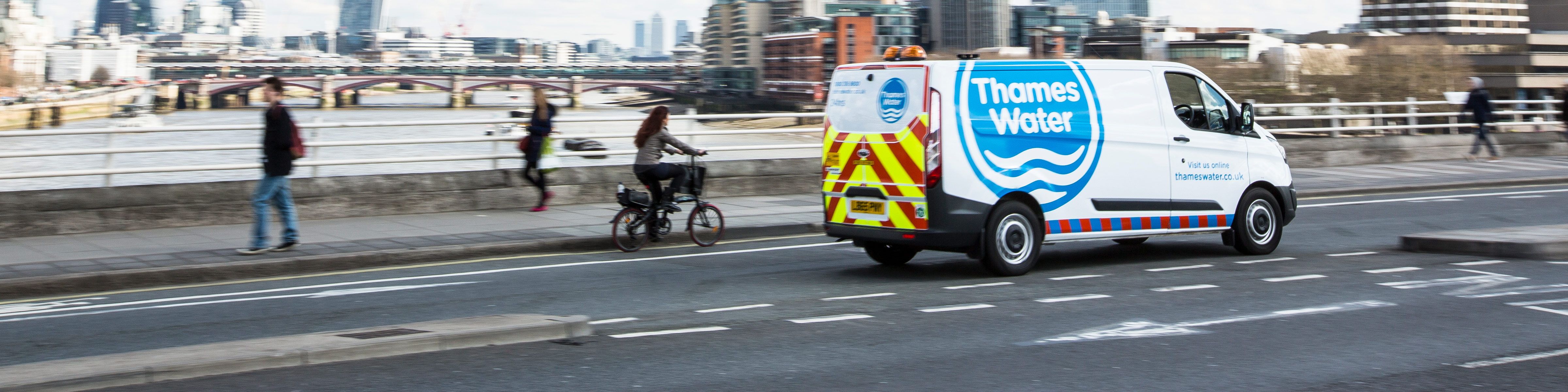 A Thames Water van crossing driving over a bridge across the River Thames