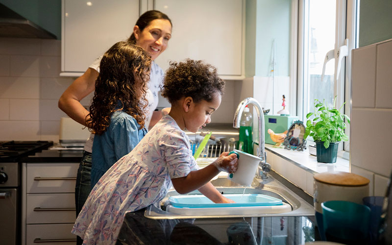 A person in the kitchen with their children