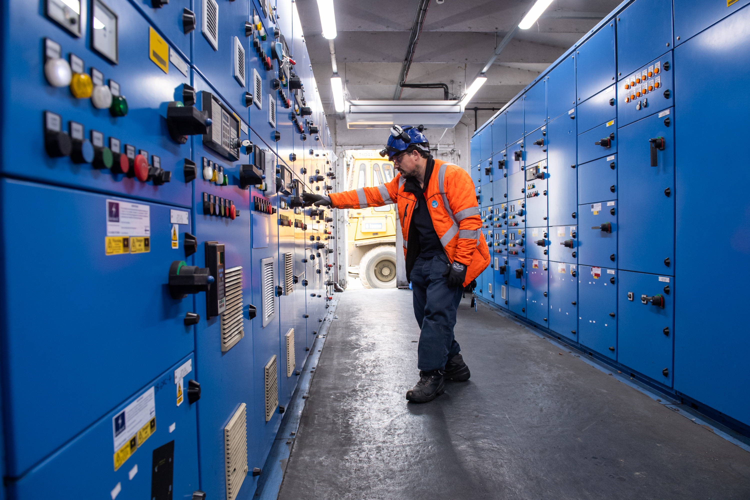 A man in orange high-vis uses a control panel at Hampton Water Treatment Works
