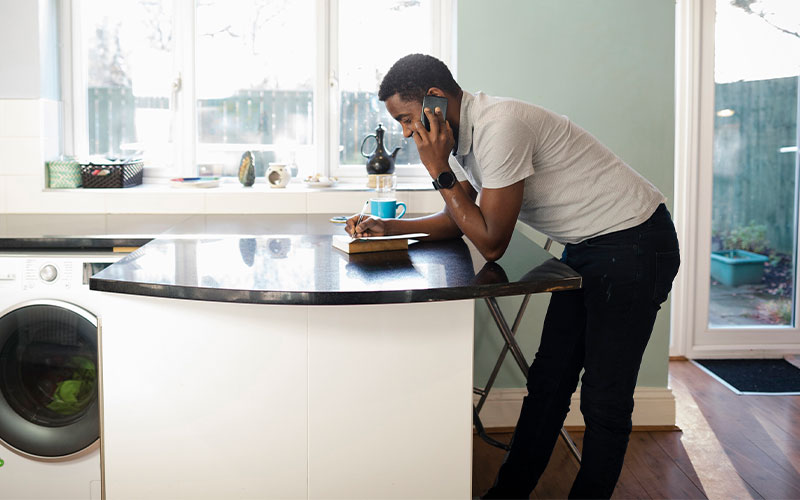 A person on the phone in the kitchen