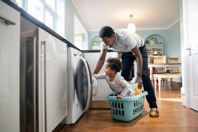 Dad and daughter fill the washing machine