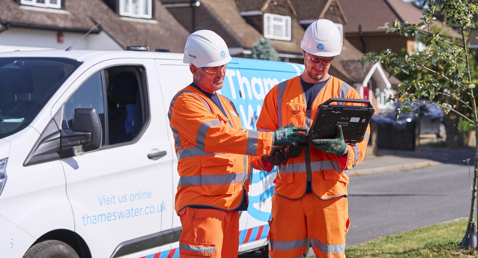 Two engineers talking next to a Thames Water van